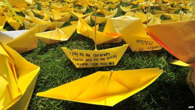 Messages written on yellow paper ships forming the shape of a heart are seen at a memorial for victims of the ferry disaster in Seoul on 7 May 2014