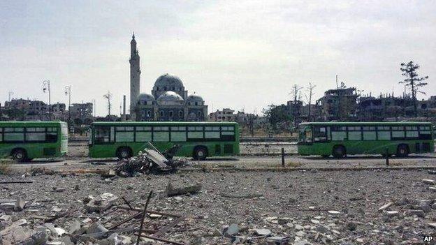 Buses carrying rebels from the Old City of Homs travel through the Khalidiya district (7 May 2014)