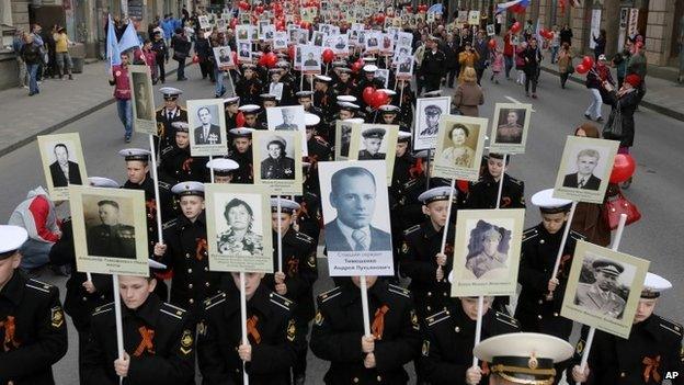 Navy cadets and local residents carry portraits of their relatives, veterans of World War Two as they celebrate upcoming Victory Day in St Petersburg