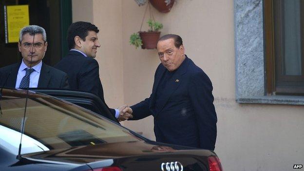 Silvio Berlusconi shakes hands with an official from the care home as he arrives to start his community service - 9 May 2014