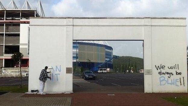 A man painting over the graffiti