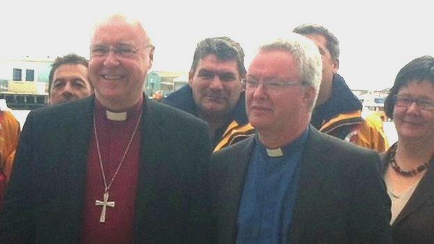 Two bishops standing next to each other surrounded by a crowd of people