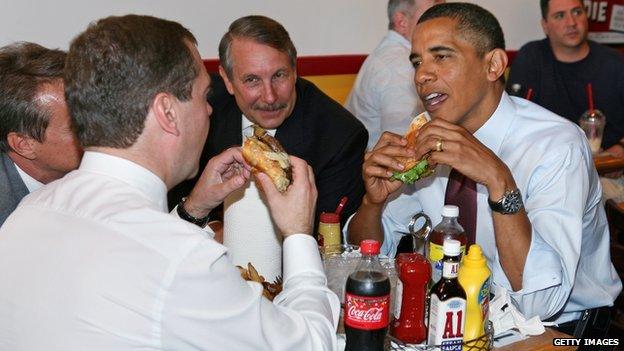 Obama eats a hamburger