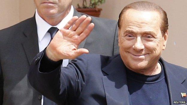 Former Italian Prime Minister Silvio Berlusconi waves as he leaves the care home