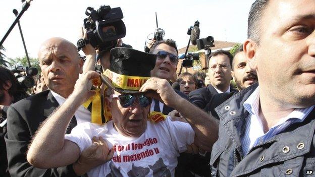 A protester is taken away by authorities outside the care home near Milan