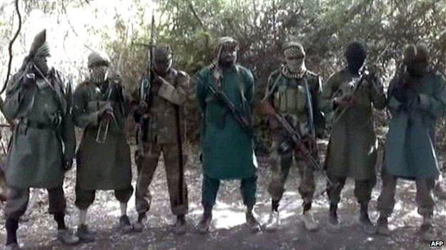 A picture taken from a video distributed to some Nigerian journalists and obtained by AFP on 5 March 2013 showing Boko Haram's leader Abubakar Shekau (C) flanked by six armed and hooded fighters in an undisclosed place