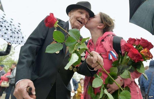 A women greets a WWII veteran as Latvia's large Russian minority gathered to mark 69 years since the end of WWII during Victory Day celebrations at the Soviet Victory Monument in Riga on May 9