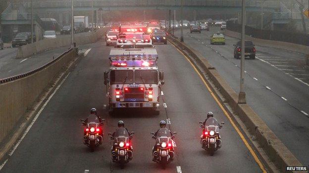 Police and fire department vehicles lead a procession along Franklin D. Roosevelt East River Drive with the unidentified remains of victims of the Sept. 11, 2001 attacks as they are returned to the World Trade Center site, Saturday, May 10