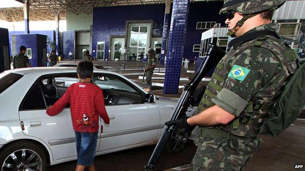 Brazilian Army soldiers stand guard at the Puente de Amistad in Foz do Iguacu, Parana state, bordering with Paraguay"s Ciudad del Este, 29 April 2014