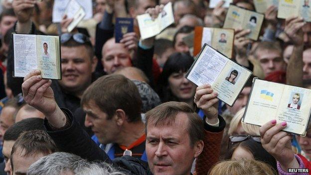People waiting to vote in Moscow hold up Ukrainian passports