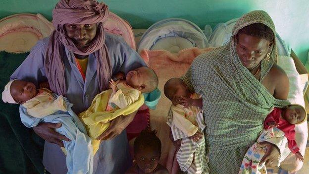 Parents holding their quadruplets