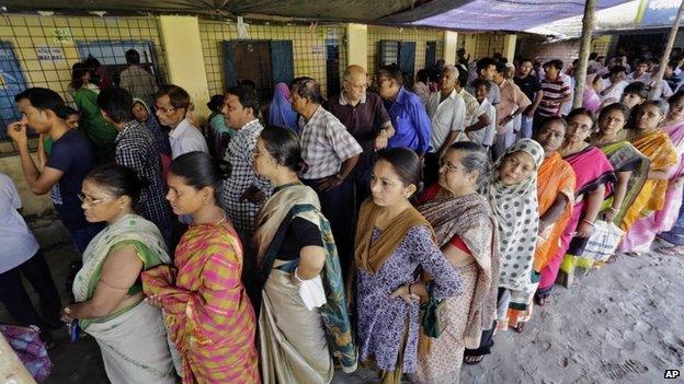 People stand in a queue to cast their vote at a polling station in Kamalgaji, on the outskirts of Kolkata, India, Monday, May 12, 2014.