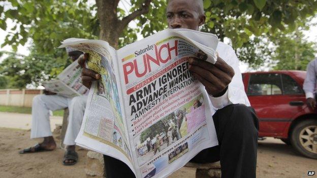 A man reads a local newspaper, with headlines stating the military was alerted four hours before abduction of secondary school Chibok girls, on a street in Abuja, Nigeria - Saturday 10 May 2014