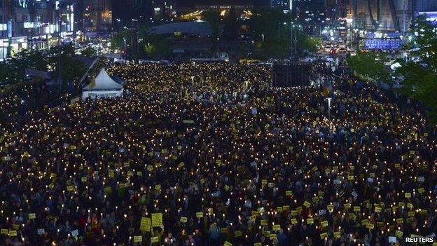 People attend a candlelight vigil to commemorate victims of the sunken Sewol passenger ferry, and to denounce the government's handling of the disaster, in Ansan, South Korea, 10 May 2014