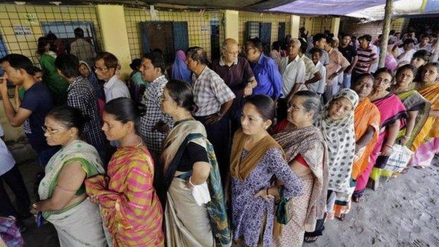 People stand in a queue to cast their vote at a polling station in Kamalgaji, on the outskirts of Kolkata, India, Monday, May 12, 2014.