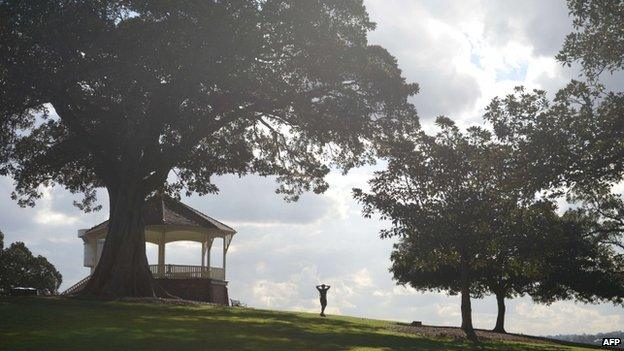 A runner walks down a hill in a park before sprinting back up again in Sydney on 13 May 2014