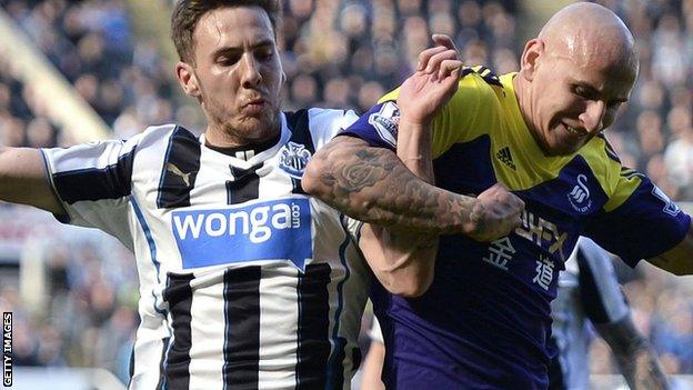 Newcastle's Dan Gosling (left) tackles Swansea City's Jonjo Shelvey