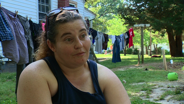 Woman sits in front of laundry on a line