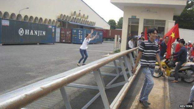 An employee of a Chinese company raises her hands while trying to stop Vietnamese protesters in Binh Duong province on 14 May.