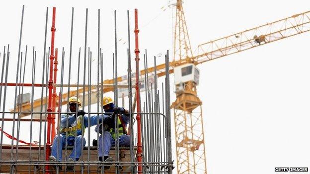 Construction workers put up scaffolding on a building site in Doha, Qatar - 10 May 2014