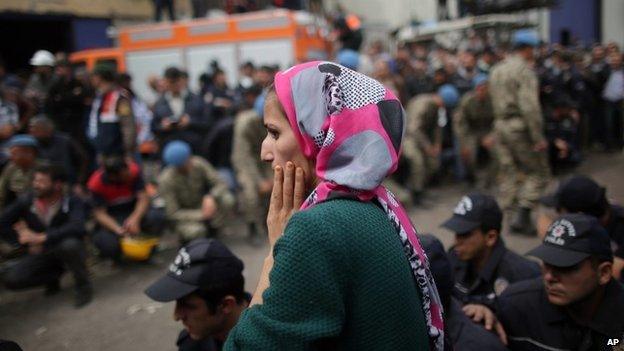 A woman looks as rescue workers carry the dead body of a miner outside the mine in Soma, western Turkey, Wednesday 14 May 2014