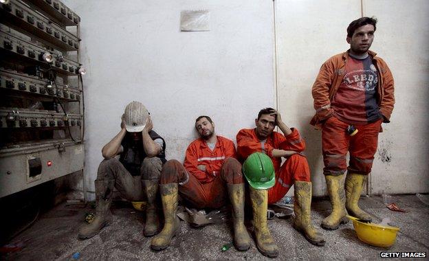 Exhausted miners rest as they await their trapped friends on 14 May 2014 in Soma, Turkey.