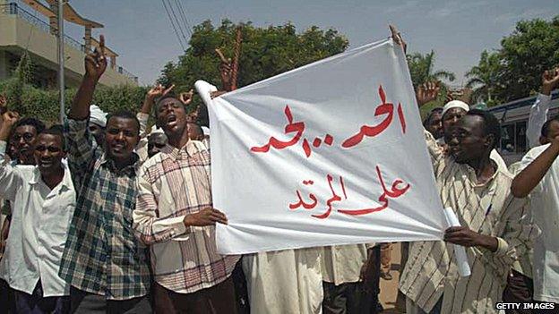 Sudanese protesters hold up a banner reading in Arabic: 'Punishment, punishment upon the apostate' during a demonstration in front of a criminal court in Khartoum in May 2005