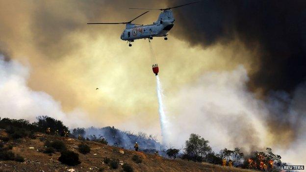 A US. military helicopter dropped water on an approaching wildfire in San Marcos, California, on 15 May 2014