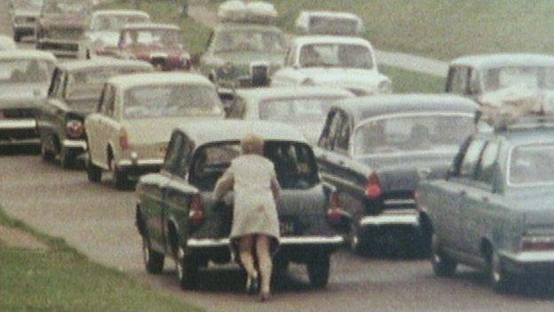Woman pushing a broken-down car