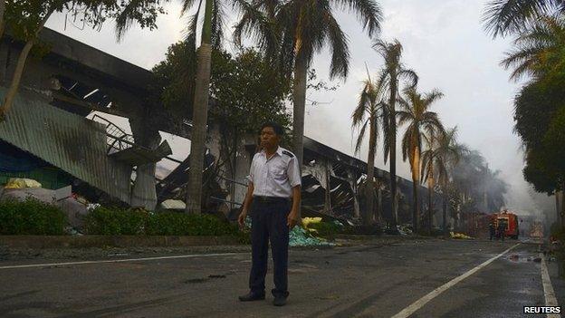 A security guard stands near a damaged Chinese owned shoe factory in Vietnam's southern Binh Duong province on 14 May 2014