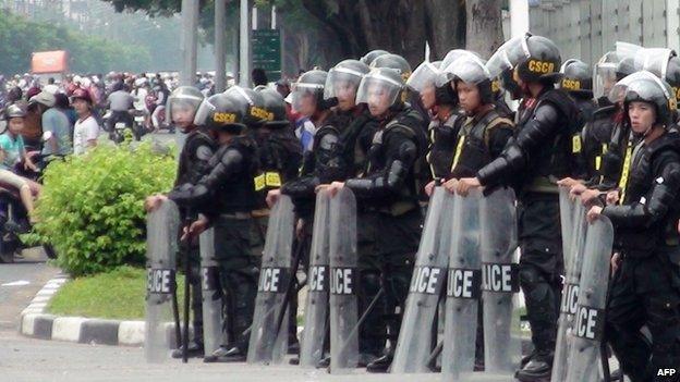 Riot police stand guard on a street outside a factory building in Binh Duong on 14 May 2014, as anti-China protesters set more than a dozen factories on fire in Vietnam