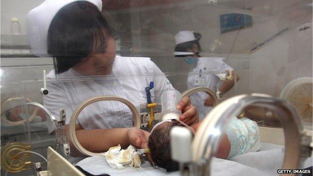 A nurse feeds milk to a 2.3-kilogram baby in an incubator at the Pujiang People's Hospital on 29 May, 2013