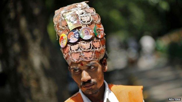 A supporter of the BJP wears headgear with badges of louts, the election symbol of the BJP