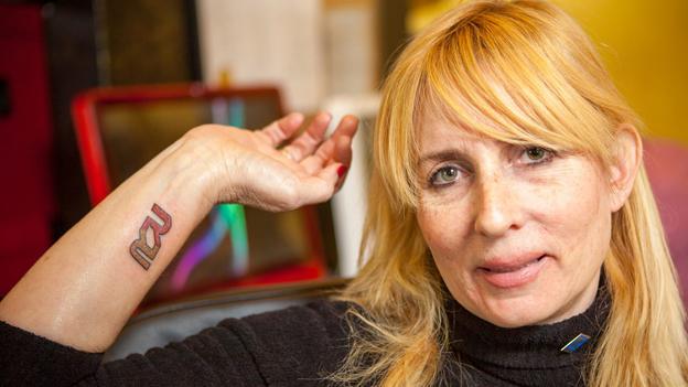 An employee of Rapid Realty, NY, shows off her corporate tattoo