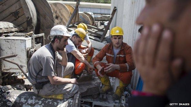 Miners wait anxiously at the entrance to the mine in Soma on 16 May 2014
