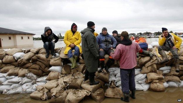 People rest on a dam of sandbags by Sava river at Sremska Mitrovica, 90km west of Belgrade 17/05/2014