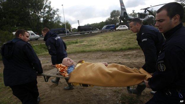 Serbian police officers carry a man from a military helicopter during flood evacuation from Obrenovac, some 30km (18 miles) southwest of Belgrade