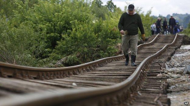 A Bosnian man walks on a damaged railway track near Tuzla 140km (87 miles) north of Sarajevo, Bosnia (17 May 2014)