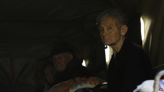 Bosnian people sit in a truck during evacuations from flooded homes in the village of Dvorovi, north of Sarajevo, on 17 May 2014.