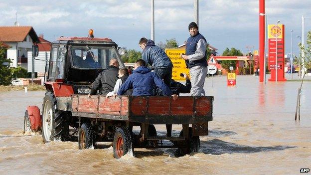 Bosnian men ride a tractor in a flooded street in the eastern-Bosnian town of Bijeljina on 17 May 2014