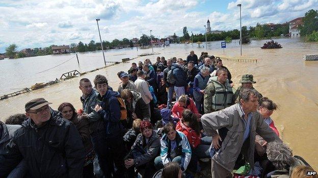 A group is evacuated by an amphibious vehicle over flooded streets in the town of Obrenovac, near Belgrade, on 17 May 2014.