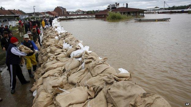 People build a dam made up of sandbags by the bank of the Sava river in Sremska Mitrovica, Serbia, on 17 May 2014