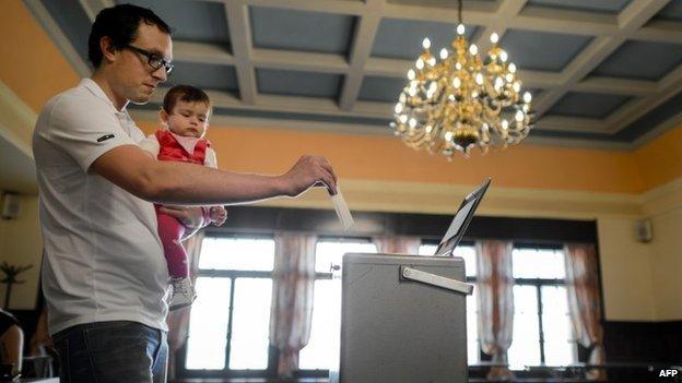 A man casts his ballot on May 18, 2014 in Bulle, western Switzerland, during a referendum on minimum wage