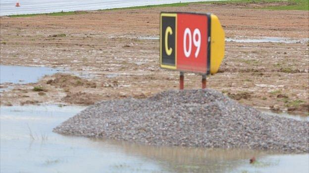 Runway sign surrounded by water