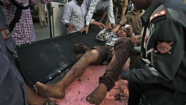 An Indian passenger who was injured after a private bus plunged off a mountain road into a deep gorge in the Indian portion of Kashmir is brought for treatment at the government medical college hospital in Jammu, India, Tuesday, May 20, 2014.