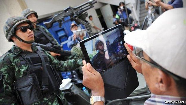 Soldiers pose for pictures on the day martial law is announced