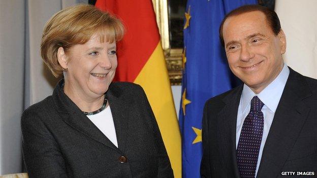 Silvio Berlusconi shakes hands with Angela Merkel during an Italy and Germany summit in Trieste in 2008