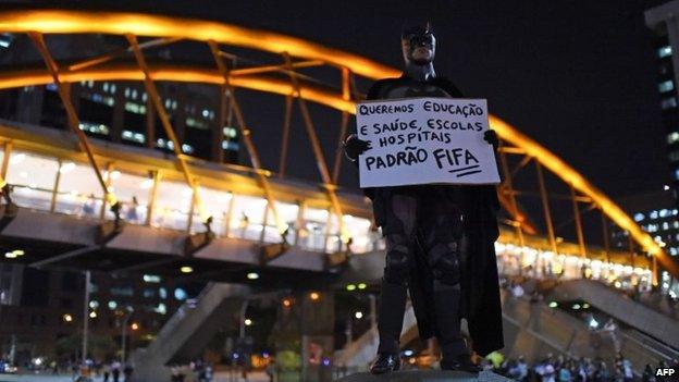 A man dressed as Batman holds a poster during a protest against the World Cup in Rio de Janeiro on 15 May, 2014