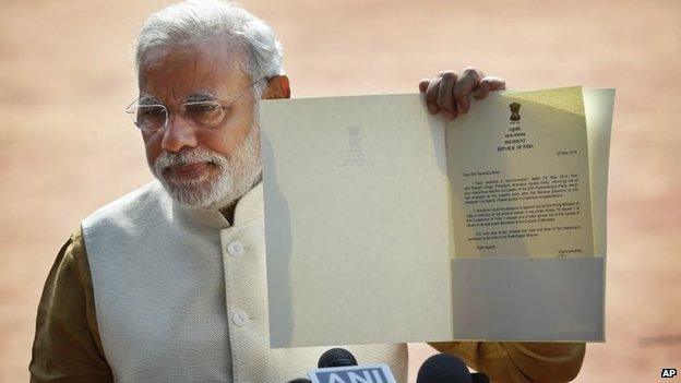 Narendra Modi displays the letter from the Indian President inviting him to form the new government