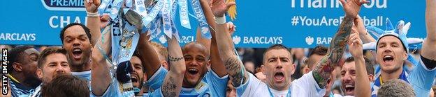 Manchester City players celebrate with the trophy after their team won the Premiership title following their victory in the English Premier League.